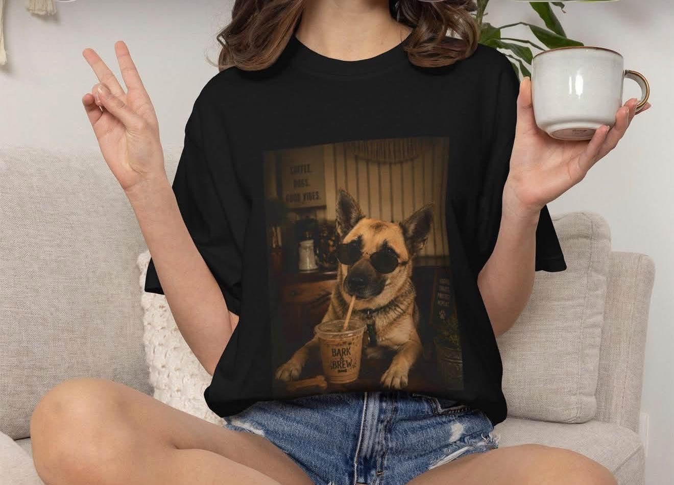 Model in a black Bark & Brew t-shirt printed with a German shepherd in sunglasses sipping iced coffee